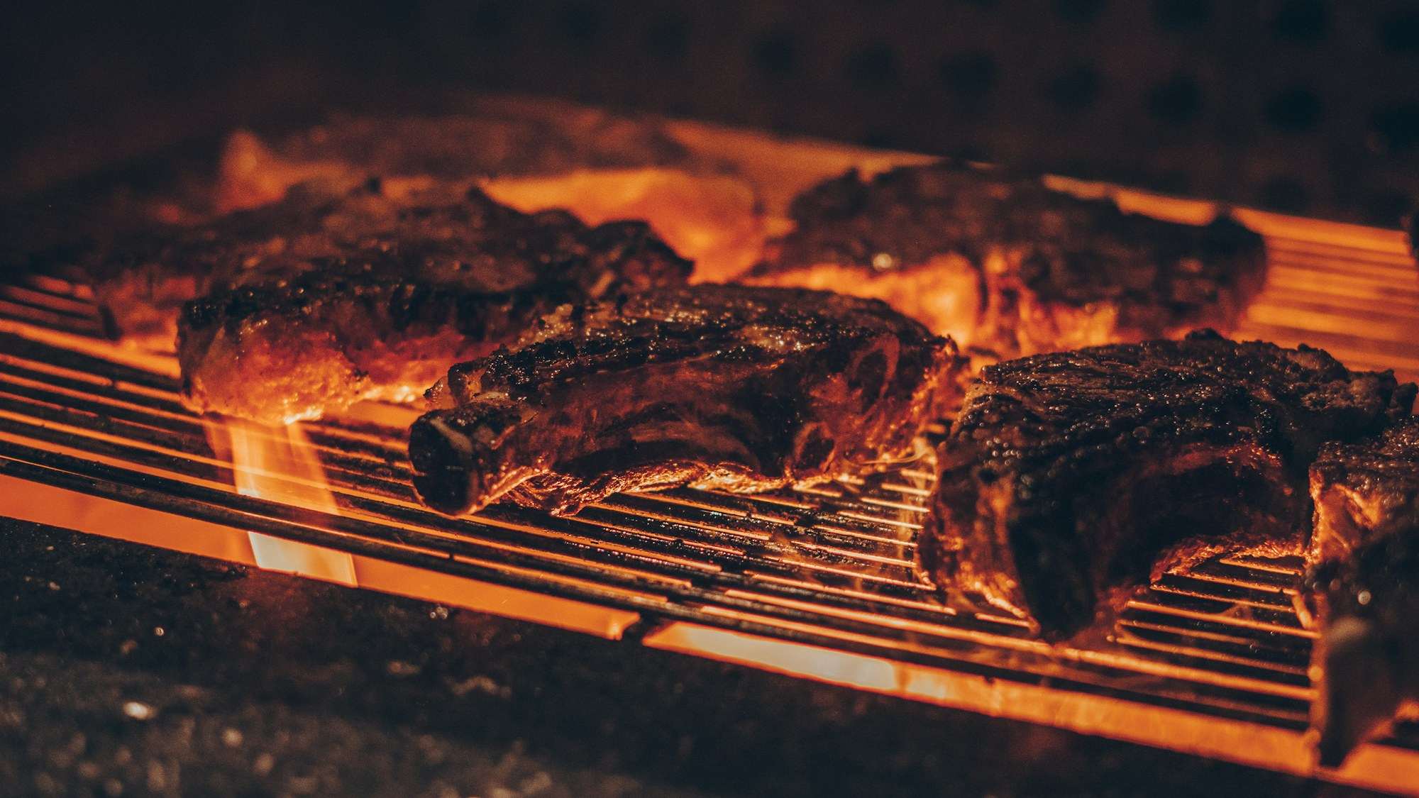 Chuletas de vaca dorándose sobre la brasa de encina