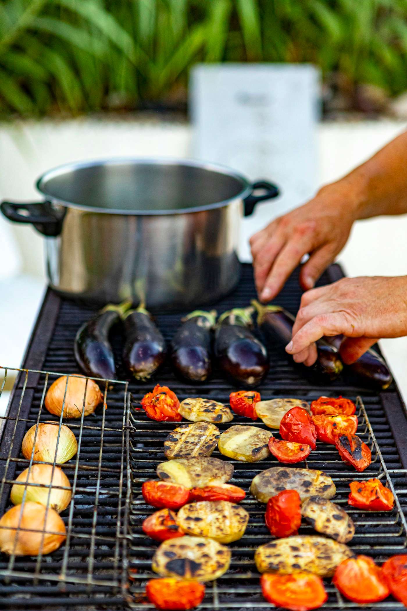 Berenjenas, tomates y pimientos asándose en la parrilla